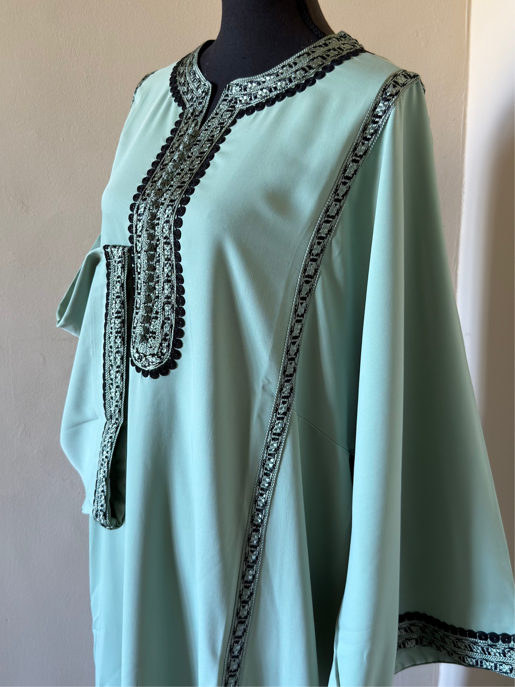 Light blue dress with black lace details on a mannequin against a plain background