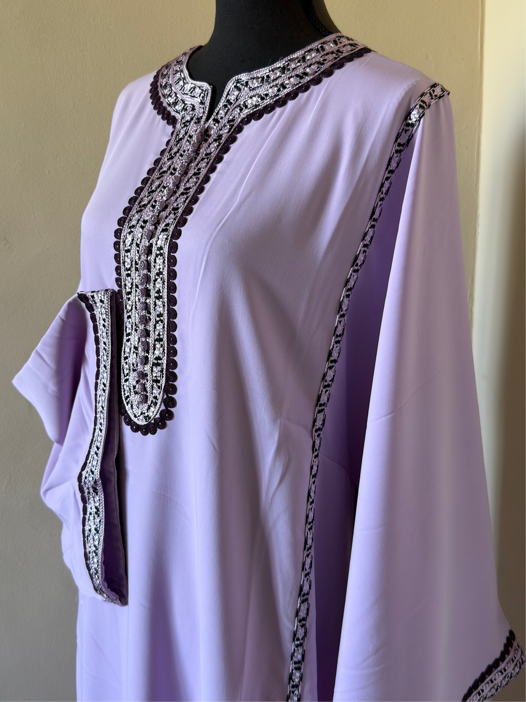 Lavender top with black and silver embroidery on a mannequin against a plain background