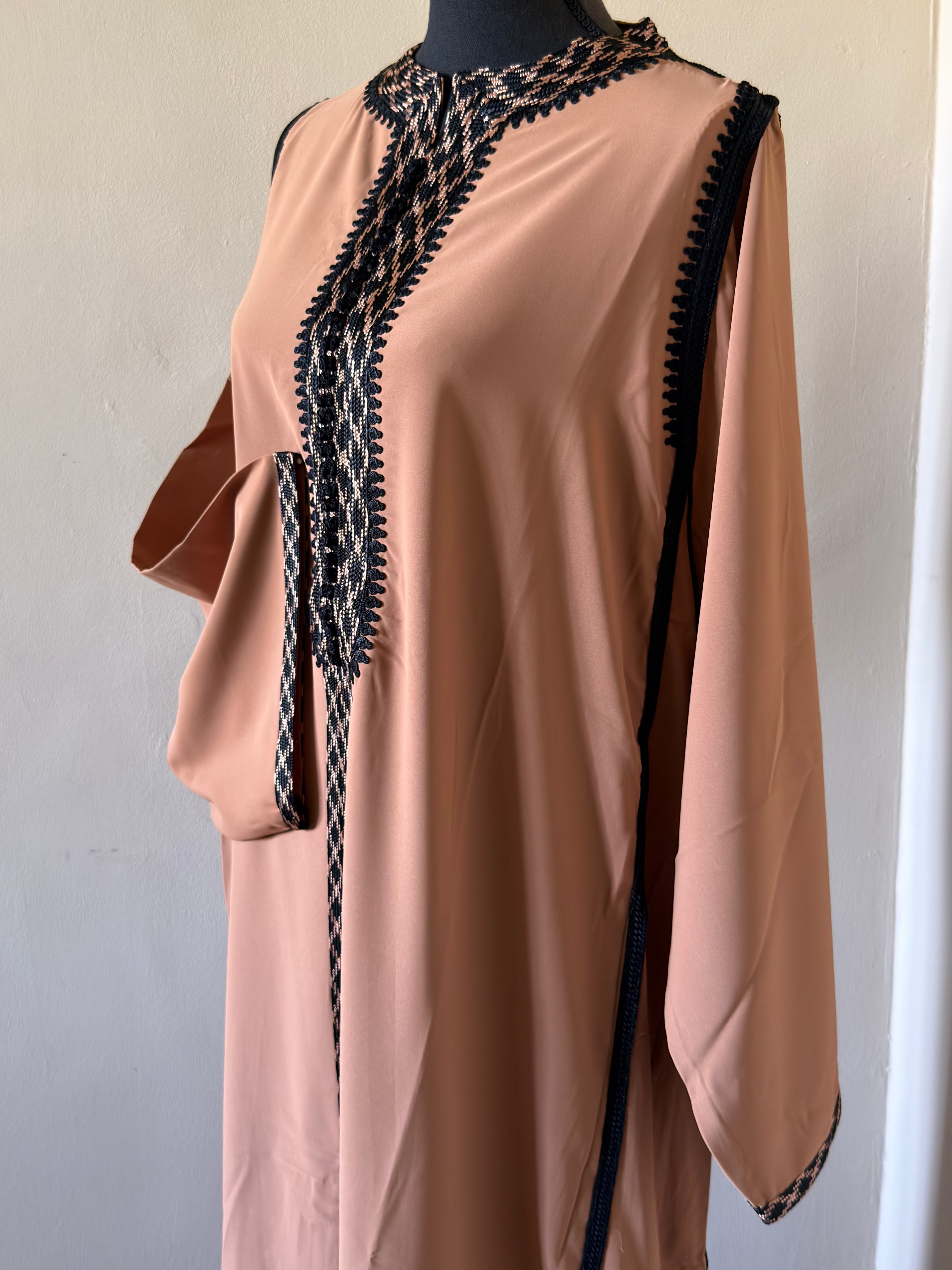 Pink dress with black lace detailing on a mannequin against a plain background